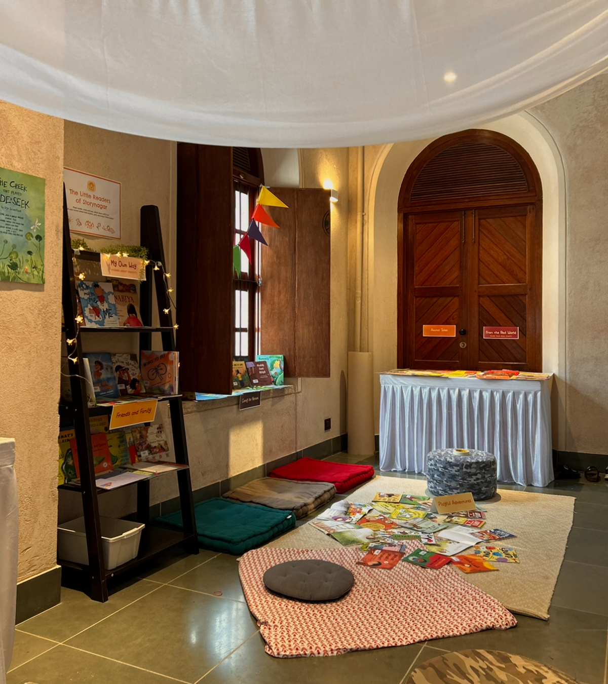 Storynagar reading corner set up with cushions and a spread of picture books