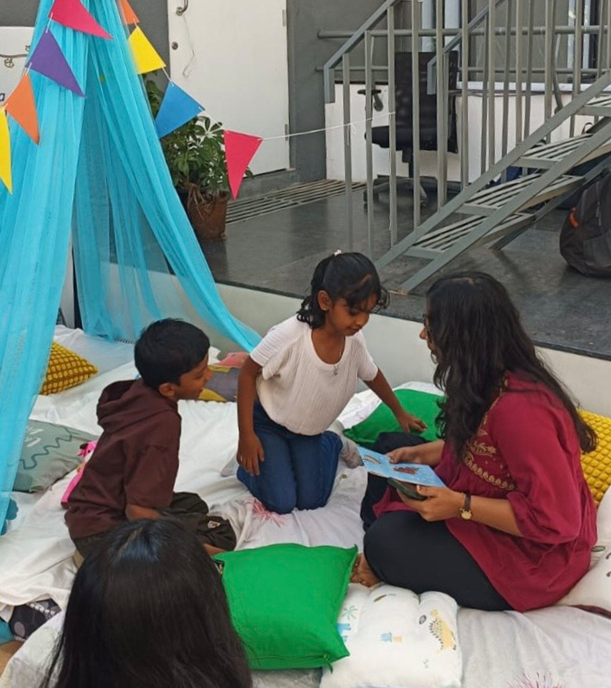 Live storytelling session at Venkatappa Art Gallery, reading to children under a canopy