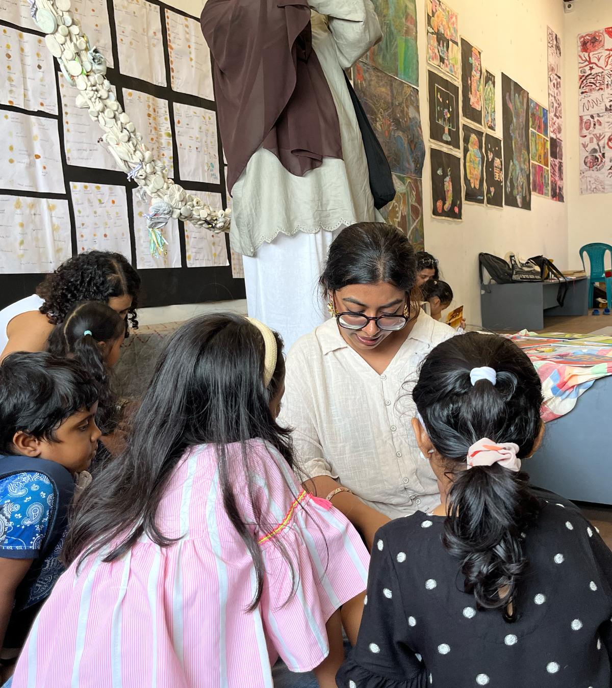 Facilitating at the ABC Room, Kochi-Muziris Biennale 2025, surrounded by children's artwork