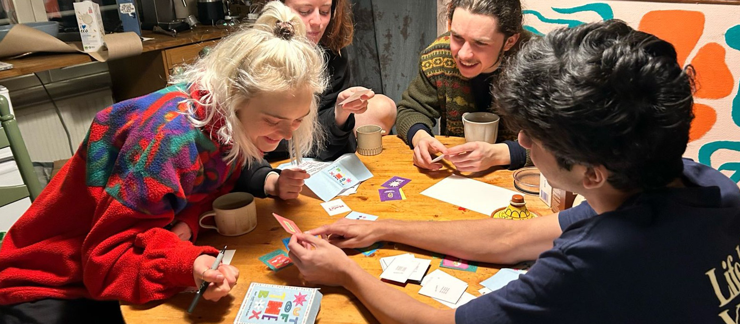 Out of the Box — friends playing the game around a kitchen table